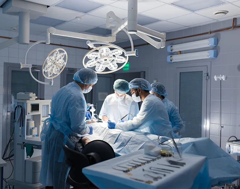a group of doctors in an operating room standing over a patient