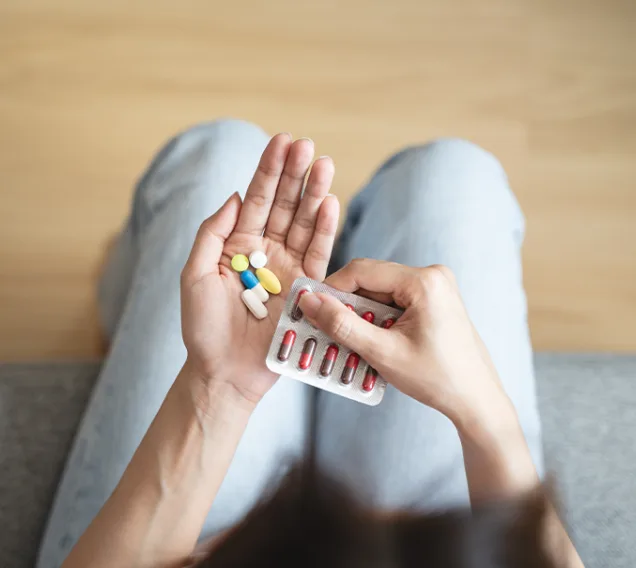 Close-Up Hands Holding Medication and Water Glass