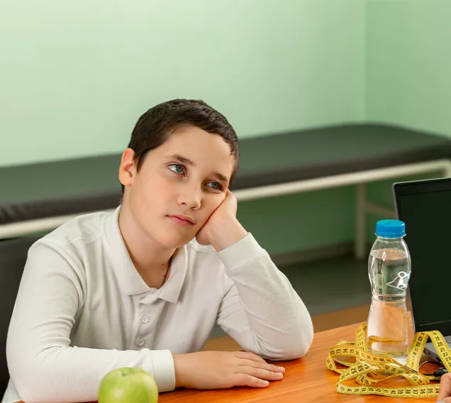image of a child sitting across from a doctor at a desk with his chin in his hands