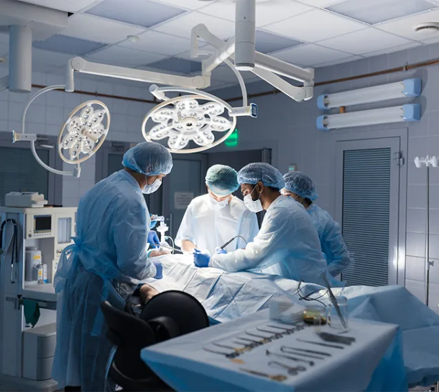 a group of doctors in an operating room standing over a patient