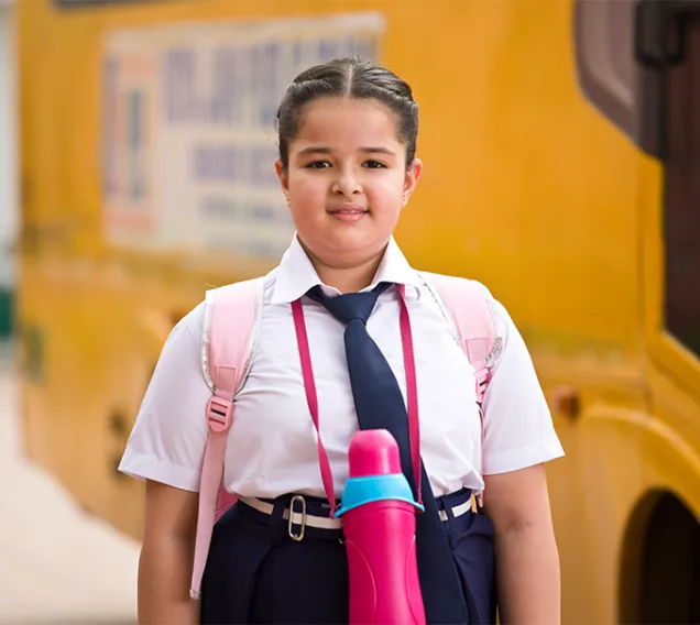 image of a young girl standing in front of a school bus