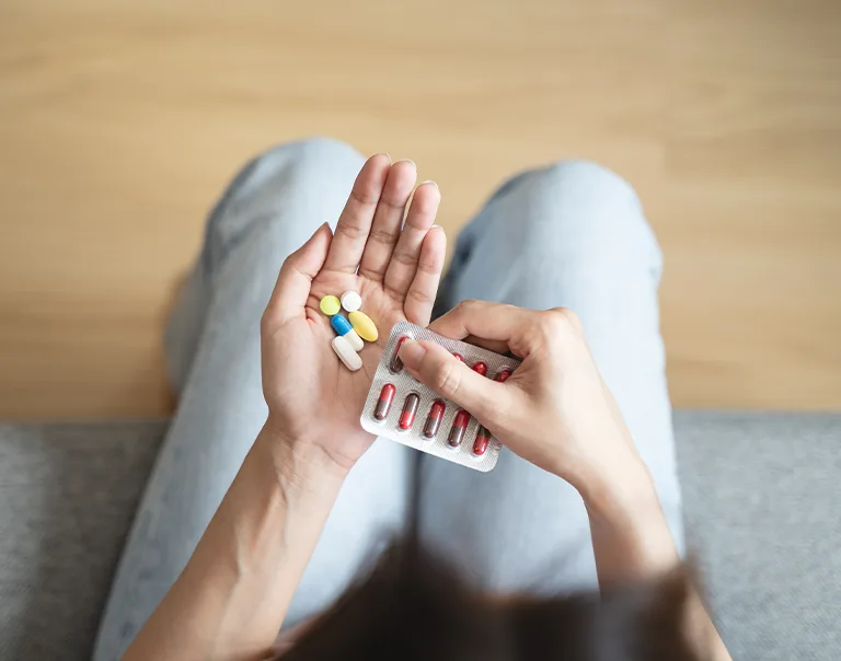 Close-Up Hands Holding Medication and Water Glass