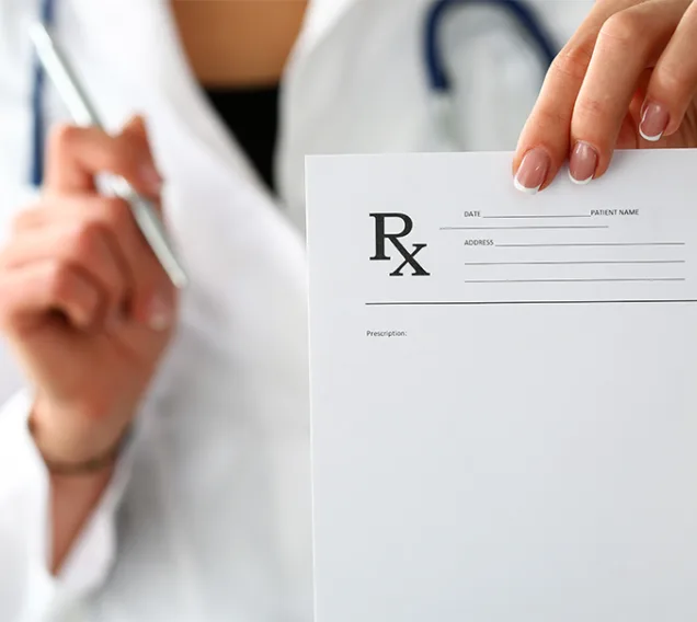 Image of a doctor wearing a white coat with a stethoscope around their neck, holding a prescription pad up to the camera with the orange Obesity Medicine Association logo in the bottom right corner