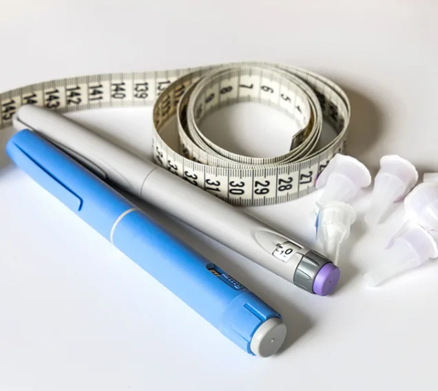 Image of 2 injectable diabetes medications with a tape measure rolled up next to it with the caps of the medications next to that